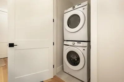 a laundry room with a washer and dryer next to a door at Cozy Grand Lake Hideaway Walk to Lake and Restaurants in Grand Lake