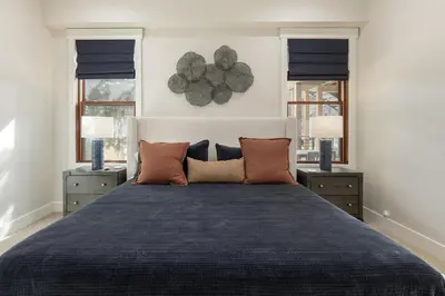 a bedroom with a large bed and two windows at Cozy Grand Lake Hideaway Walk to Lake and Restaurants in Grand Lake