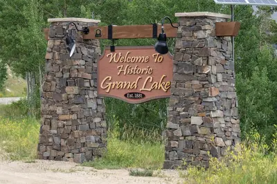 a welcome sign for a historic grand lodge at Cozy Grand Lake Hideaway Walk to Lake and Restaurants in Grand Lake