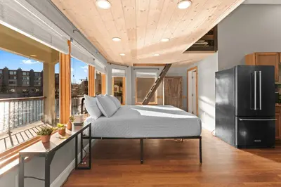 a bedroom with a bed and a refrigerator on a balcony at Lakeshore 1 in Keystone
