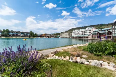 a river with houses and purple flowers in a town at Lakeshore 1 in Keystone