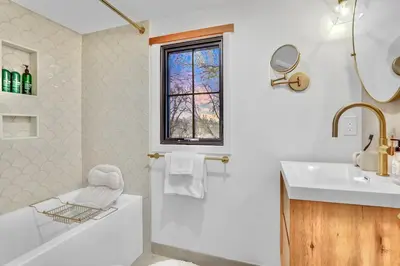 a white bathroom with a tub and a sink at Peaceful Ranch Overlooking Mustangs with Full Kitchen & Fireplace in Longmont
