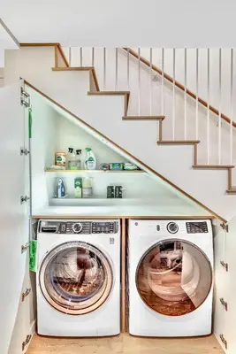 a washer and dryer in a laundry room with stairs at Peaceful Ranch Overlooking Mustangs with Full Kitchen & Fireplace in Longmont