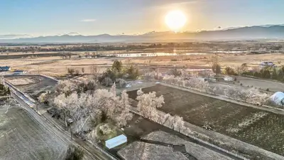 an aerial view of a field with the sun in the background at Peaceful Ranch Overlooking Mustangs with Full Kitchen & Fireplace in Longmont
