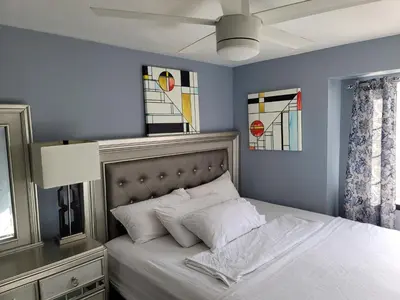 a bedroom with a bed with white pillows and stained glass at Denver Layover B&B in DEN