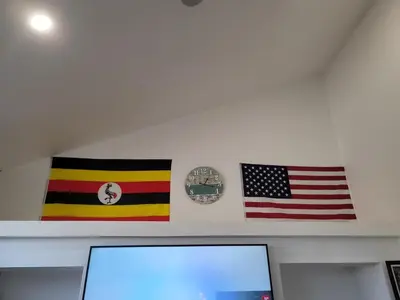 two flags on a wall next to a computer monitor at Denver Layover B&B in DEN