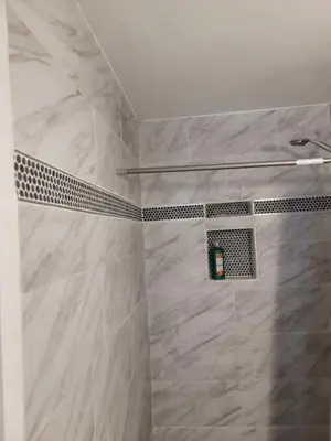 a bathroom with a shower with white marble tiles at Denver Layover B&B in DEN