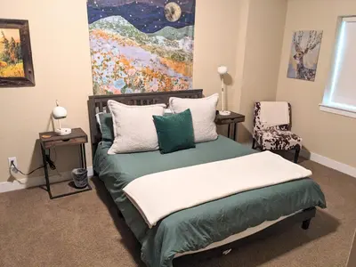 a bedroom with a bed with a painting on the wall at 3 BR Private Mountain Retreat in Granby