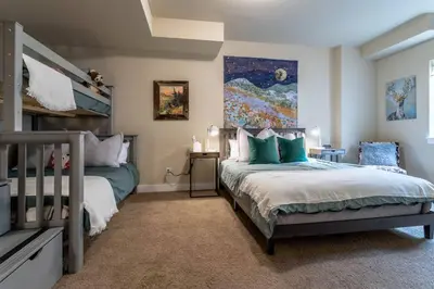 a bedroom with two beds and a painting on the wall at 3 BR Private Mountain Retreat in Granby