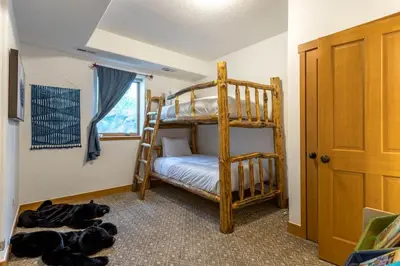 a bedroom with bunk beds and two dogs laying on the floor at Luxury Getaway in Winter Park Fraser in Granby