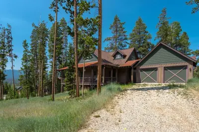 a house on a hill with trees and a driveway at Luxury Getaway in Winter Park Fraser in Granby
