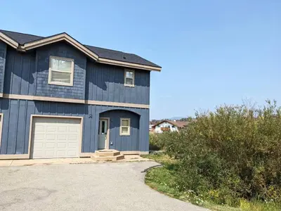 a blue house with a garage at Central and Cozy Townhouse in Fraser