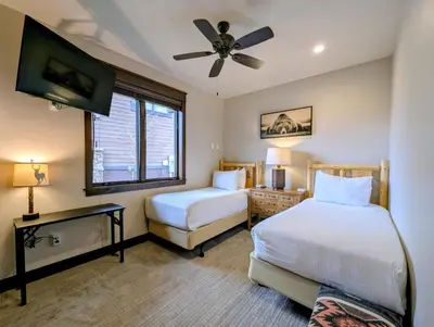 a bedroom with two beds and a ceiling fan at River Run Townhomes 73 by SummitCove Lodging in Keystone