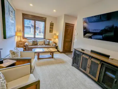 a living room with a large flat screen tv at River Run Townhomes 73 by SummitCove Lodging in Keystone