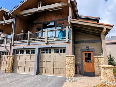 a house with two garage doors and a balcony at River Run Townhomes 73 by SummitCove Lodging in Keystone