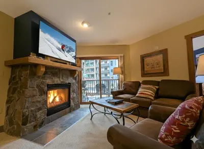 a living room with a fireplace and a flat screen tv at Red Hawk Lodge 2242 by SummitCove Lodging in Keystone