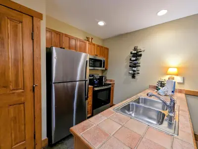 a kitchen with a stainless steel refrigerator and a sink at Red Hawk Lodge 2242 by SummitCove Lodging in Keystone