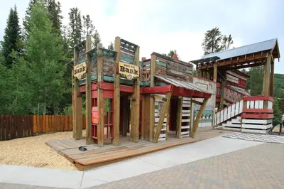 a playground with a play structure with wooden signs at Red Hawk Lodge 2242 by SummitCove Lodging in Keystone