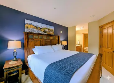a bedroom with a large bed with a blue wall at Red Hawk Lodge 2242 by SummitCove Lodging in Keystone