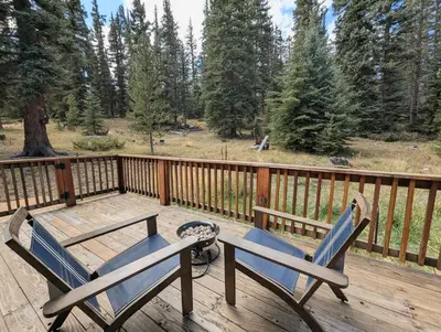 two chairs and a table on a wooden deck at Goldenrod Home 88 by SummitCove Lodging in Keystone