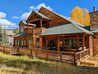 a large wooden house with a large deck at Goldenrod Home 88 by SummitCove Lodging in Keystone