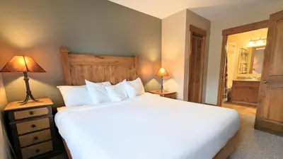 a bedroom with a large white bed and two lamps at Springs 8886 by SummitCove Lodging in Keystone