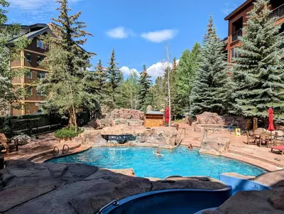 a pool in a resort with people swimming in it at Springs 8886 by SummitCove Lodging in Keystone