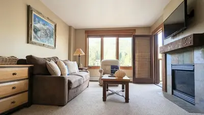 a living room with a couch and a fireplace at Springs 8886 by SummitCove Lodging in Keystone