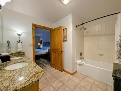 a bathroom with a sink and a tub and a toilet at Dakota Lodge 8499 by SummitCove Lodging in Keystone
