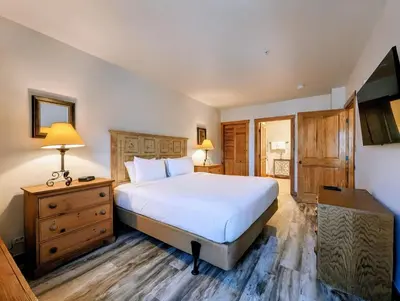 a bedroom with a bed and a dresser and a television at Dakota Lodge 8499 by SummitCove Lodging in Keystone