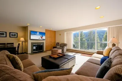 a large living room with a couch and a tv at Saints John 2525 by SummitCove Lodging in Keystone