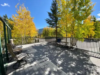 a deck with two chairs and a fence at Saints John 2525 by SummitCove Lodging in Keystone