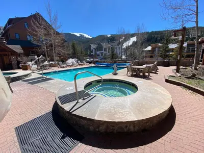 a hot tub in a stone circle next to a pool at Dakota Lodge 8451 by SummitCove Lodging in Keystone