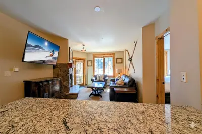 a living room with a flat screen tv on the wall at Dakota Lodge 8451 by SummitCove Lodging in Keystone