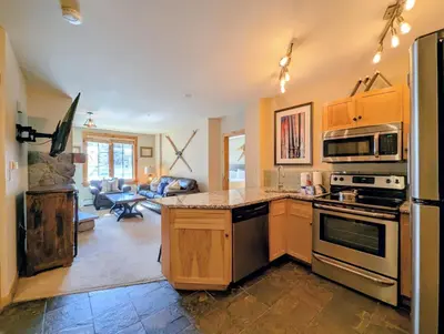 a kitchen with stainless steel appliances and a living room at Dakota Lodge 8451 by SummitCove Lodging in Keystone