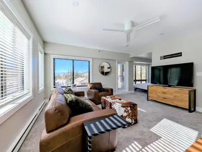 a living room with a couch and a flat screen tv at Slopeside 2793B by SummitCove Lodging in Keystone