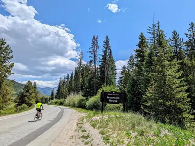 a person riding a bike down a road with a sign at Slopeside 2793B by SummitCove Lodging in Keystone