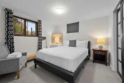 a bedroom with a bed and a chair and a window at 1815 Bluebell New in Boulder