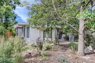 a small white house with a tree in the yard at 1815 Bluebell New in Boulder