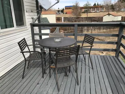 a table and four chairs on a deck at 4 Bedroom Vacation House With Pikes Peak view Pet-friendly in Aurora