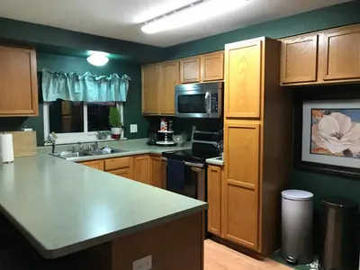 a kitchen with wooden cabinets and a counter top at 4 Bedroom Vacation House With Pikes Peak view Pet-friendly in Aurora