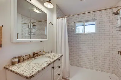 a white bathroom with a sink and a shower at Mtn-View Retreat with Deck and Hot Tub in Estes Park! in Estes Park