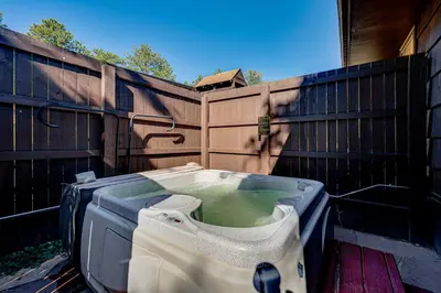 a bath tub sitting in front of a fence at Mtn-View Retreat with Deck and Hot Tub in Estes Park! in Estes Park
