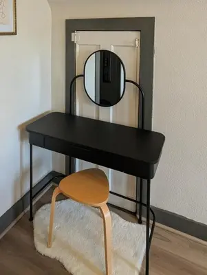 a black desk with a mirror and a stool at The Green House, RiNo in Denver