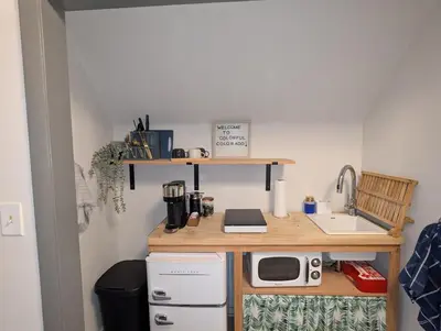 a small kitchen with a sink and a microwave at The Green House, RiNo in Denver