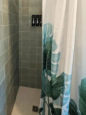 a bathroom with a shower with a shower curtain at The Green House, RiNo in Denver