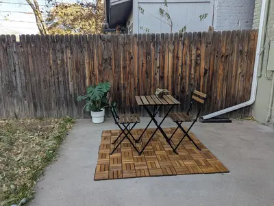 a patio with a table and two chairs in front of a fence at The Green House, RiNo in Denver