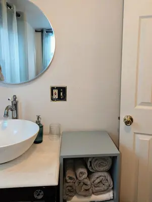 a bathroom with a sink and a mirror and towels at The Green House, RiNo in Denver
