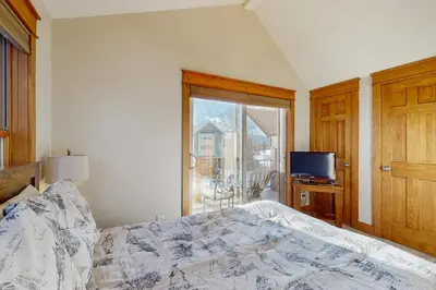 a bedroom with a bed and a tv and a window at Grizzly Peak Lodge in Granby