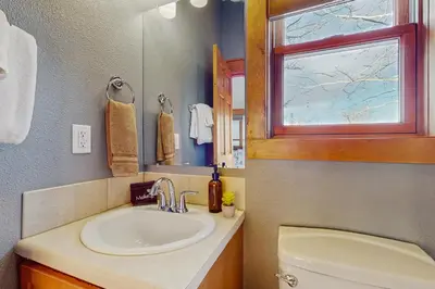 a bathroom with a sink and a toilet and a window at Grizzly Peak Lodge in Granby